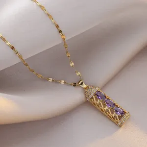 Titanium gold necklace featuring cylindrical hollow pendant with purple stones
