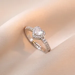 Anillo de corazón plateado ajustable con halo de circonitas sobre fondo de seda