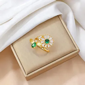 Golden sunflower ring set with green emerald cubic zirconia and bee design on silk cloth