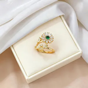 Detail of gold open ring featuring green stone daisy and sparkling bee motif