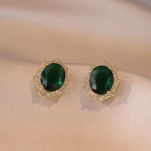 Boucles d'oreilles vintage en or avec gemme ovale verte et halo de zircons