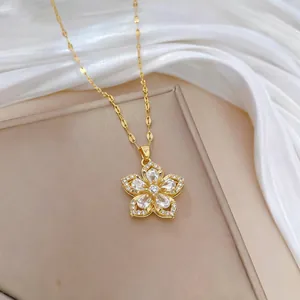 Macro view of rotating golden five-petal flower pendant with sparkling zircons