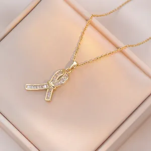 Elegante collana con ciondolo a fiocco dorato e zirconi su sfondo in raso di seta