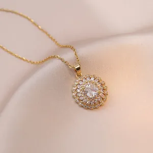 Elegant gold necklace with sparkling round zircon pendant on luxury silk fabric background