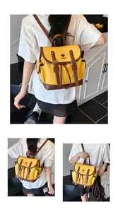 Detail of vintage mango yellow backpack with floral embroidery and brown straps