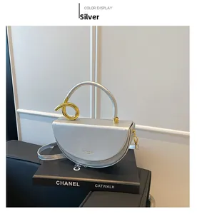 Detail of silver saddle bag showing golden knot handle and fashion logo on leather