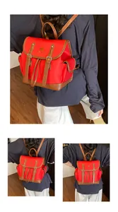 Detail of red travel backpack with tulip embroidery and brown faux leather straps