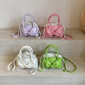 Chic bucket bags with large bows in purple, pink, white, and green on stone steps