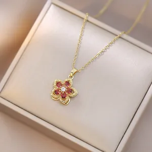 Detail of a rotating zircon flower necklace with red petals in a premium gift box