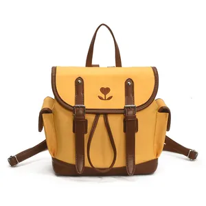Yellow canvas backpack with brown leather trim and heart flower embroidery detail