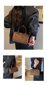 Detailansicht der braunen matten Boston-Tasche mit geprägtem Schriftzug und Metallreißverschluss