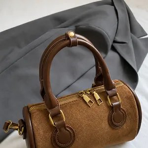 Detailansicht der Doppelgriffe und Goldbeschläge der braunen Retro-Schultertasche
