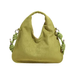 Avocado green suede tote bag with minimalist curved handle and decorative side rope knots