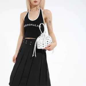 Stylish white bucket bag with metal studs and drawstring, shown on a fashion model