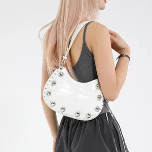 White minimalist croissant bag with silver rivets and glossy finish shown on model