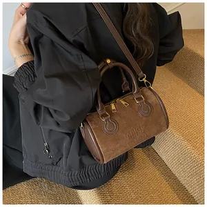 Makrodetail der dunkelbraunen Vintage-Boston-Tasche mit geprägtem Text und Mattleder