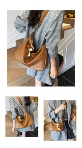 Détail d'un grand sac cabas marron vintage avec bandoulière et pendentif ours