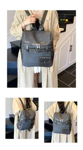 Detail of dark grey canvas backpack with leather accents and retro buckle straps