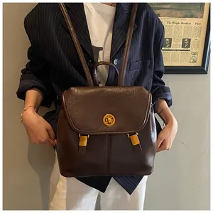 Dettaglio di uno zaino vintage in pelle marrone con fibbia in metallo e patta