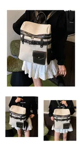 Detail of canvas and leather backpack featuring belt buckle and zip closure