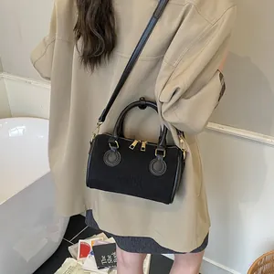 Minimalistische schwarze matte Boston Bag mit Logoprägung und goldenen Metalldetails