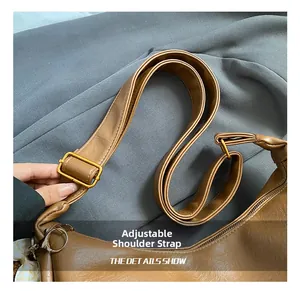 Détail de la bandoulière réglable en cuir marron avec boucle en métal doré