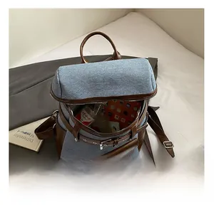 Detail showing the internal capacity and blue denim fabric of this stylish retro backpack