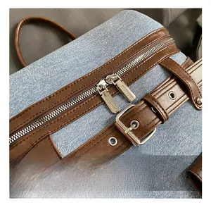 Detail show of light blue denim backpack with premium silver zippers and leather straps