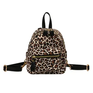 Fashionable leopard print backpack with gold hardware and black leather straps on white background