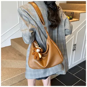 Détail du sac hobo en similicuir caramel texturé avec un joli pendentif ours