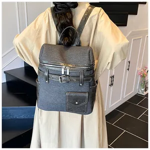 Close-up of minimalist gray canvas backpack with contrast leather trim and buckle details