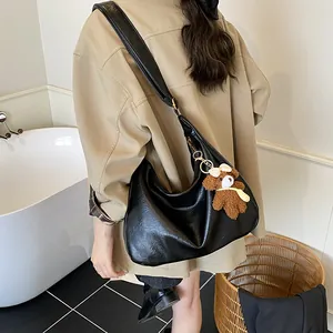 Sac fourre-tout croissant noir en cuir brillant avec un joli pendentif d'ours en peluche