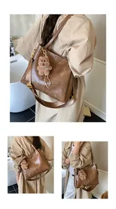 Detail van vintage bruine draagtas met verstelbare riem en pluche berenhangertje