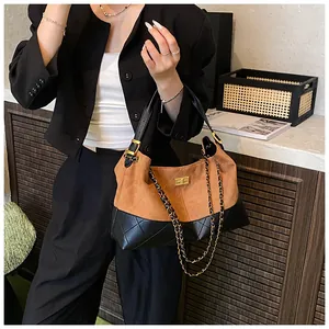 Detail of quilted tote bag with brown suede and black leather, featuring golden lock