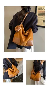 Detail van suède caramel tote bag met donut hanger en verstelbare lederen riem