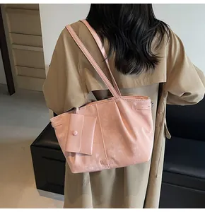 Pink faux leather tote bag with subtle vintage texture and matching small pouch charm