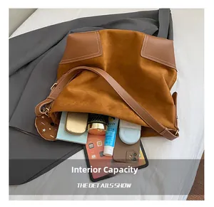 Detailweergave van de grote binnenruimte van de bruine suède shopper met accessoires