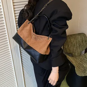 Quilted suede and leather tote bag with gold chain strap shown on model for daily use