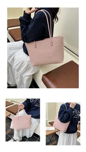 Close-up of pink woven tote bag showing detailed herringbone texture and slim shoulder straps