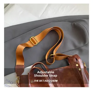 Detail van de verstelbare brede canvas schouderriem met gouden metalen gesp op bruine tas