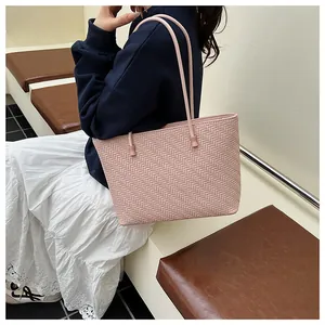 Detailed close-up of pink woven tote bag with herringbone texture and leather straps