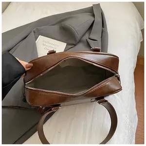 Detail view of the spacious interior with zipper closure and smooth brown PU leather