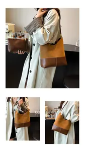 Detail of dual-tone tote set showing large bucket bag and small pouch in soft brown leather