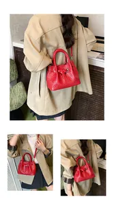 Detail of red woven bucket bag showing intricate glossy texture and leather strap