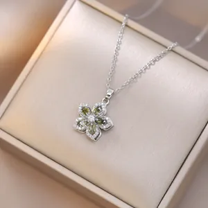 Rotating silver necklace with five-petal flower pendant featuring green zircon stones