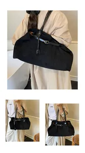 Macro shot of large black tote bag featuring matte texture and shiny leather straps