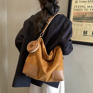 Bruine suède shopper met leren riemen en pluche hanger, achteraanzicht gedragen door model