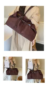 Detail showing the dark brown tote bag's matte texture and stylish buckle strap design
