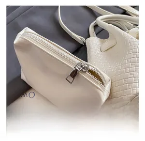 Close-up of premium silver metal zipper and intricate woven texture on the white bucket bag