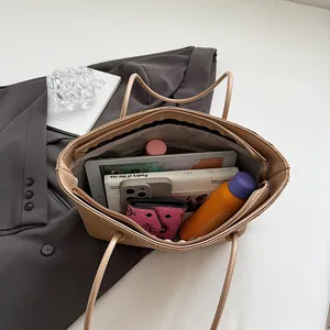 Spacious woven wheat pattern tote bag in beige leather showing large interior capacity